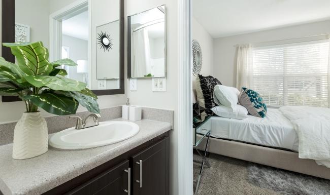 a bathroom with a sink near a bedroom