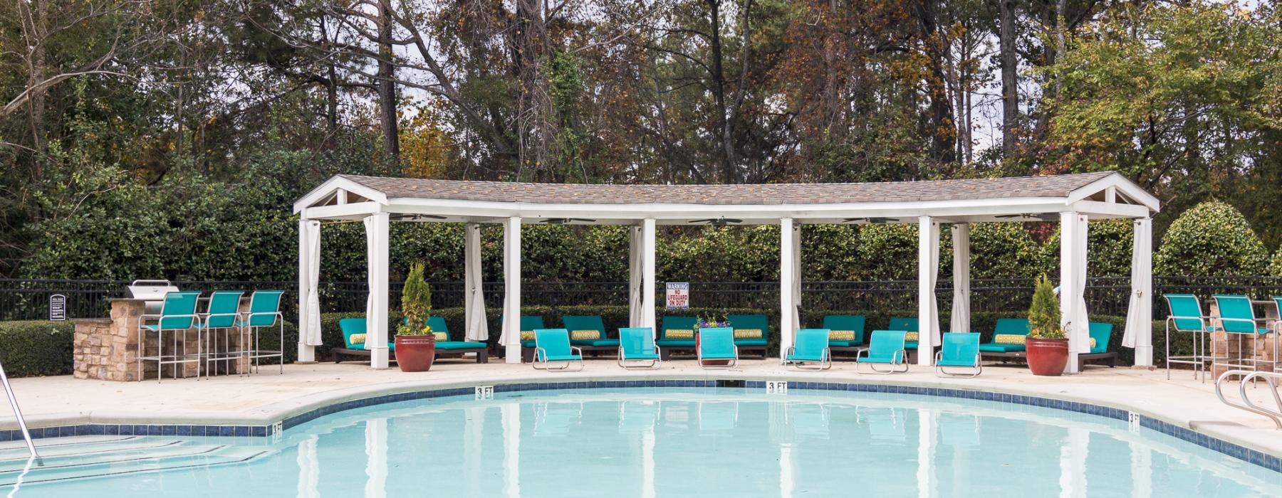 a swimming pool with chairs around it
